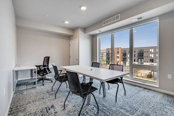 a meeting room with a large window and a table and chairs